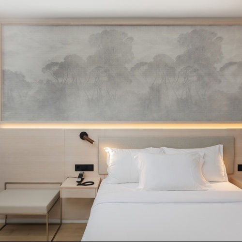 a hotel room with a painting on the wall above the bed