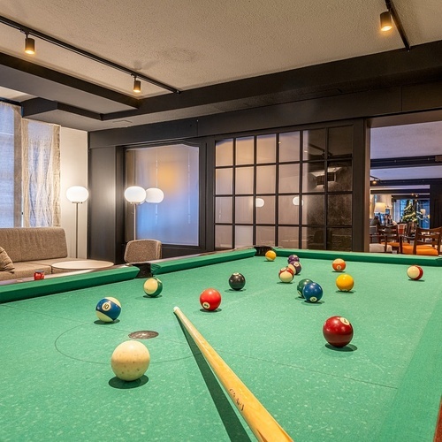 a pool table with balls and cues in a living room