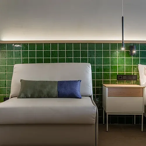 Modernes Hotelzimmer mit beiger Couch, grünen Kacheln und Lampe | Estival Maramar | Estival Group | Tarragona | Offizielle Website