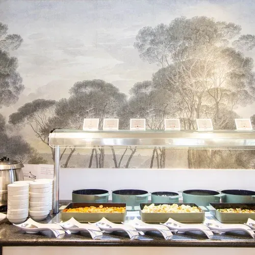 Restaurant interior amb taules i cadires, vistes a jardins. Estival Isla Cristina 4* Superior | Huelva | Web Oficial.