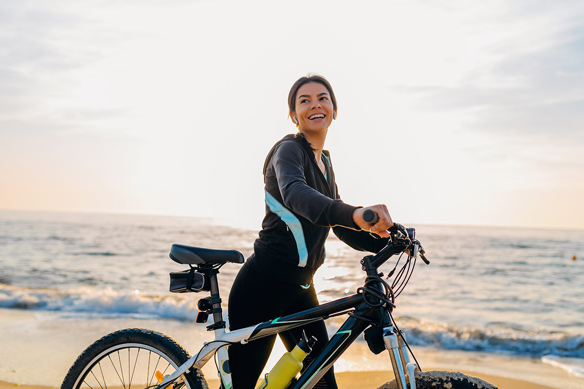 Woman with ESTIVAL: Corporativa on beach at sunrise