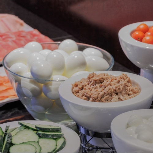 a bowl of hard boiled eggs next to a bowl of tuna