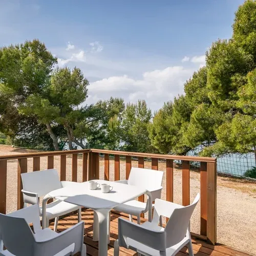Terrasse avec mobilier blanc et vue sur la pinède et la mer | Estival Torre de la Mora