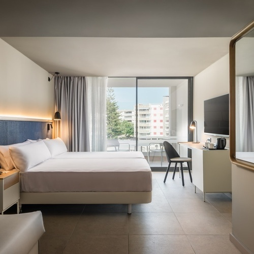 a hotel room with two beds a couch and a desk