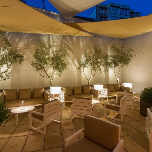 a patio with a couch and chairs under a canopy