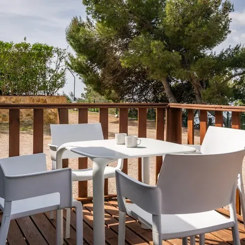 Table et chaises blanches sur la terrasse en bois, Estival Torre de la Mora, Tarragone.