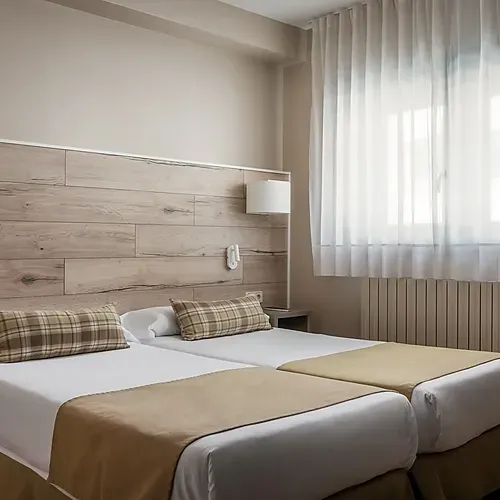 ESTIVAL: Corporativa: Sofá moderno y cama en suite con diseño minimalista.