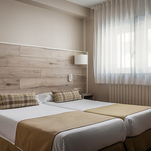 ESTIVAL: Corporate: Modern sofa and bed in a minimalist suite.