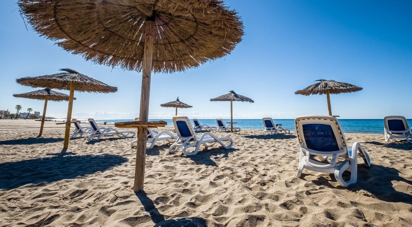 ein Holzdeck mit weißen Stühlen und einem Tisch darauf