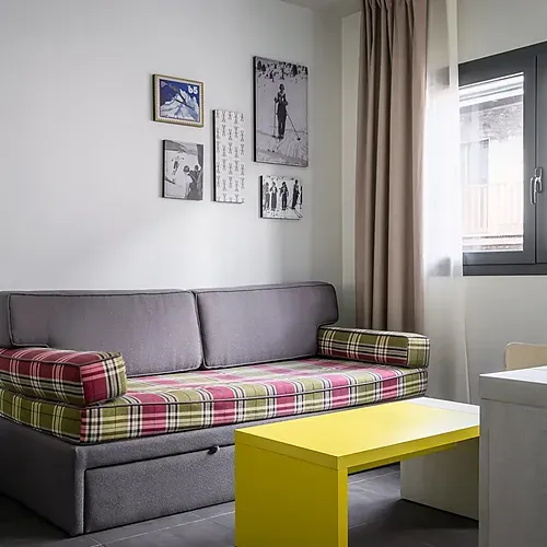 Hotel Cristina | Andorra | Estival Group | Official Web: Cozy bedroom with teddy bear and slippers.