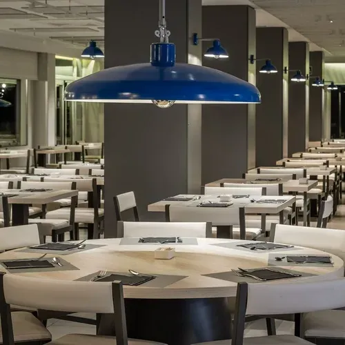 Modern dining room at ESTIVAL: Corporativa, set tables, blue pendant lights.