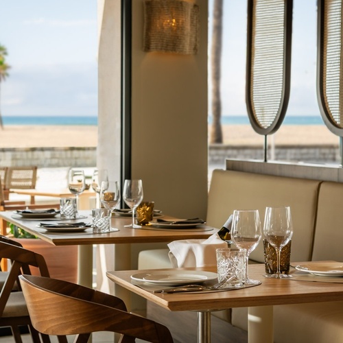 a restaurant with a view of the ocean and palm trees