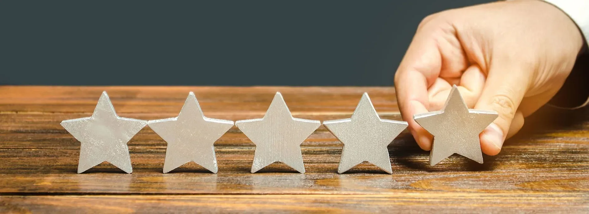 Awards and commitments | Estival Group Hotels & Resorts: Hand placing a star, signifying top ratings and dedication.