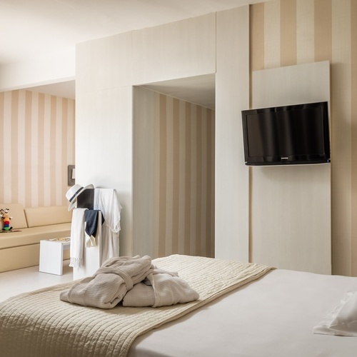 una habitación con una cama y una televisión en la pared