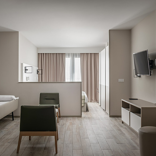 ESTIVAL: Habitación moderna con cama nido, sillones y mesa auxiliar.