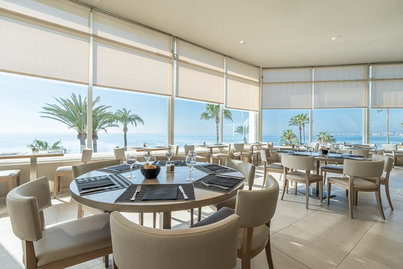 mesas y sillas en un restaurante con vista al océano