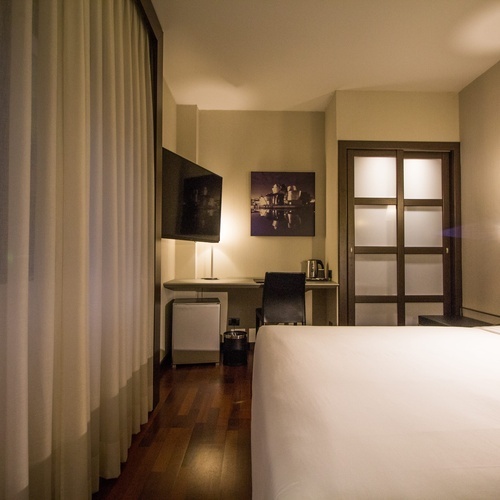 a hotel room with a bed a desk and a television