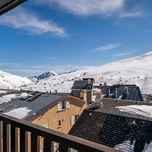 Snow-covered mountain ESTIVAL: Corporativa view from hotel balcony with village rooftops.
