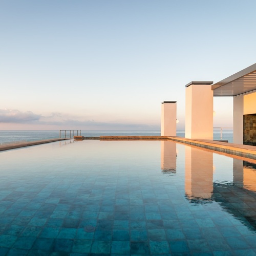 a large swimming pool with a view of the ocean