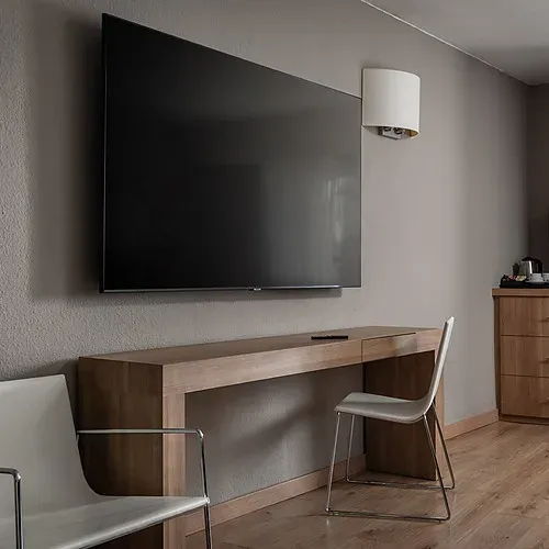 Hotel Sporting Andorra | Grandvalira Pas de la Casa | Official Web: Triple room with snowboard art and mountain decor.