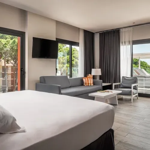 ESTIVAL: Corporate room with sea view, bed, sofa, and balcony.