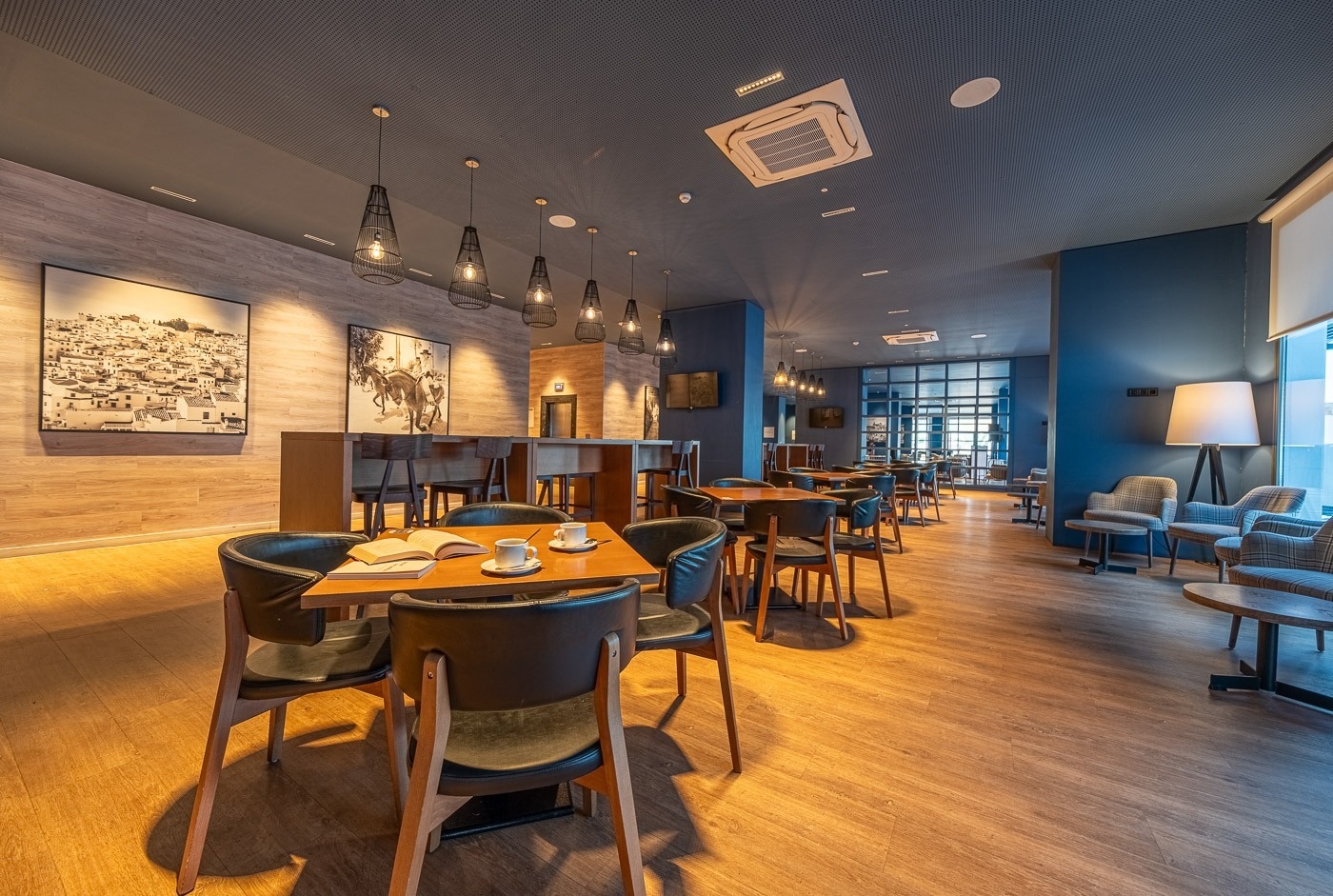 una habitación llena de mesas y sillas con una pintura en la pared