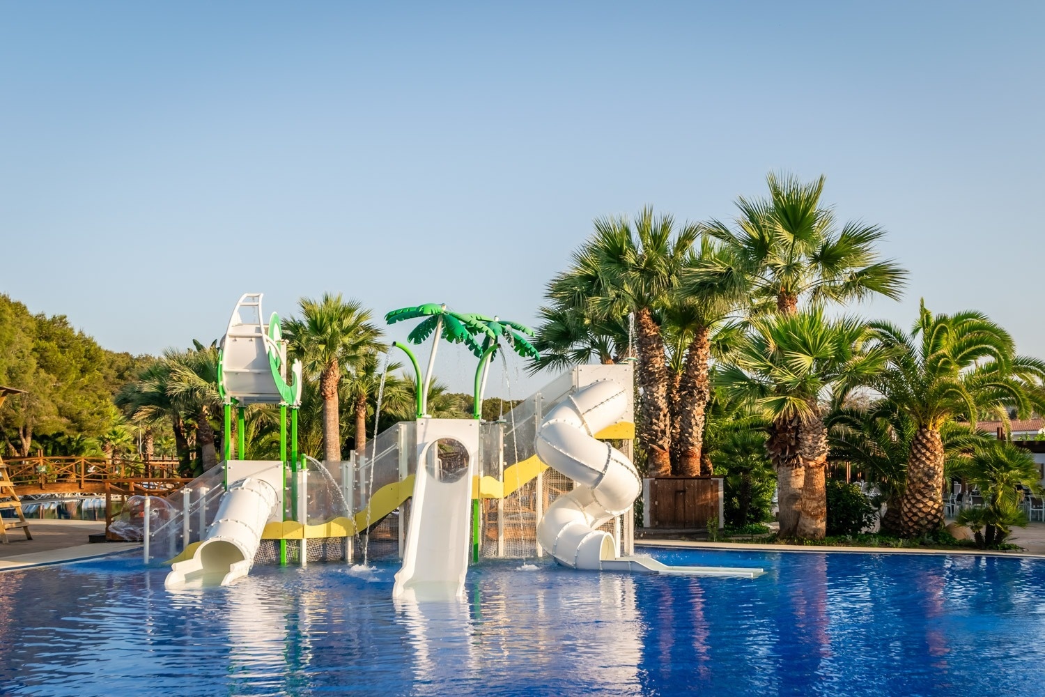 una piscina con toboganes y sillas azules alrededor