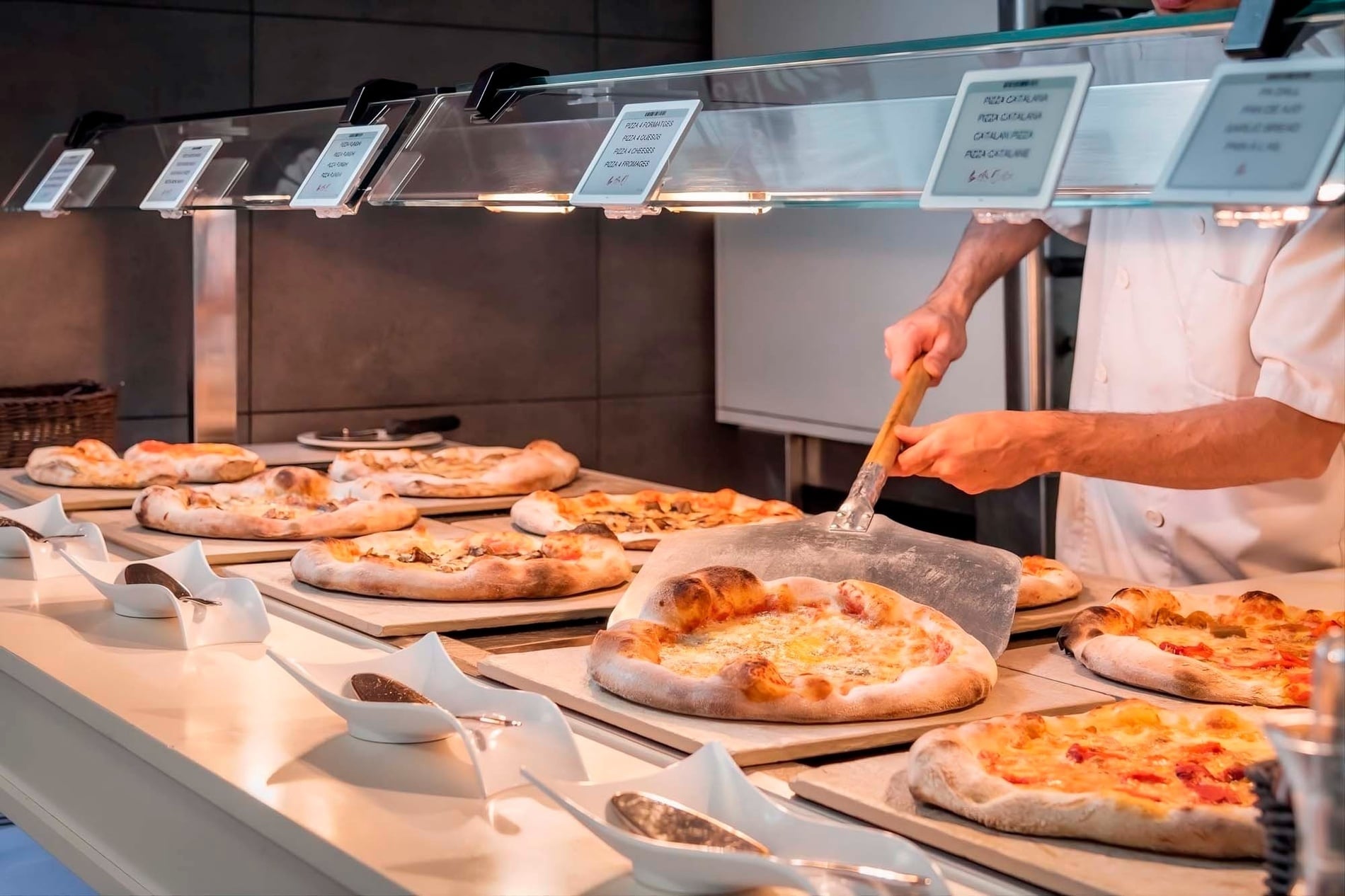 ein Mann bereitet Pizzas in einem Restaurant zu