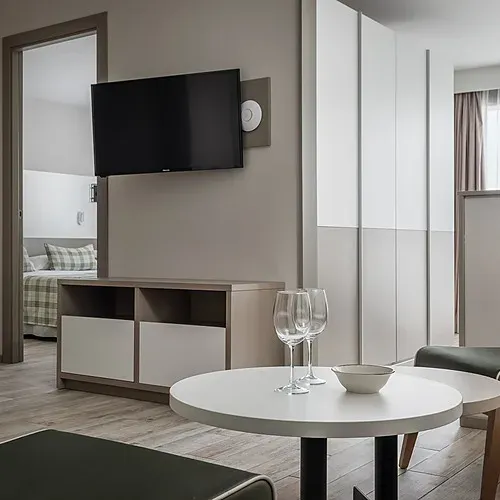 ESTIVAL: Modern corporate suite with kitchen, dining, and living area.