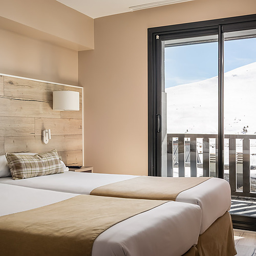 Hotel room with two beds, wooden headboard, balcony with ESTIVAL: Corporativa mountain view.