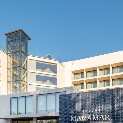 an aerial view of a large white building with balconies