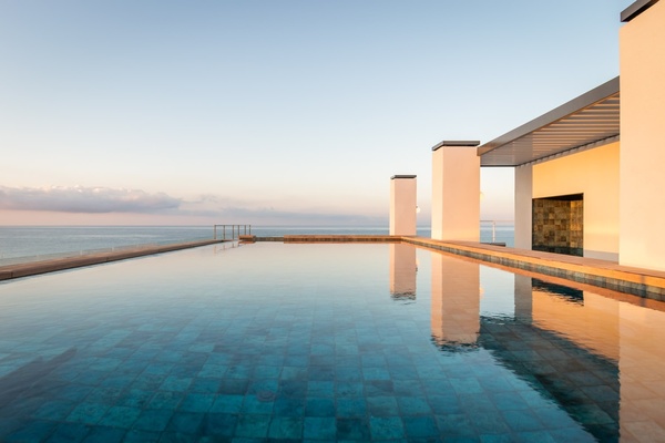a group of people standing on a balcony overlooking the ocean