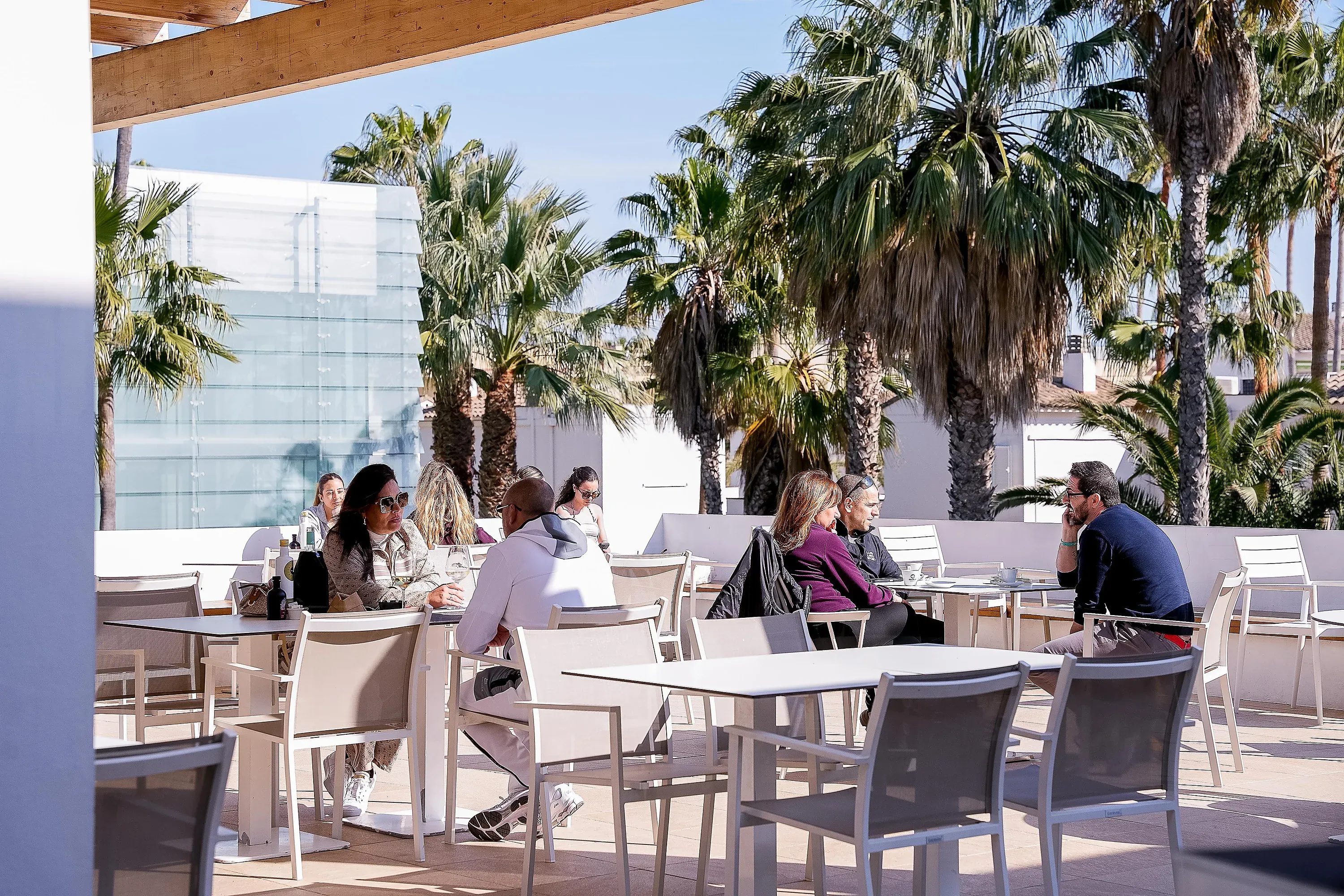 ESTIVAL: Corporativa Restaurant mit gedeckten Tischen und Holzstühlen.