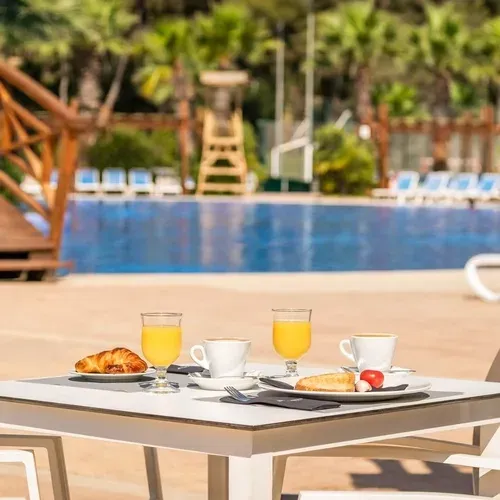 Petit-déjeuner Estival Torre de la Mora : jus, café, croissant au bord de la piscine.