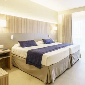 Habitación doble con camas separadas en ESTIVAL: Park Silmar, decorada en tonos neutros y madera.