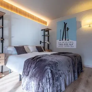 Habitación doble moderna en ESTIVAL: Sporting Andorra, con dos camas y manta gris.