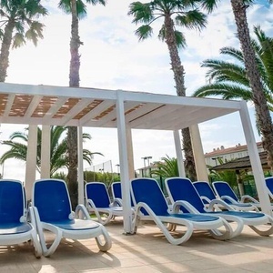 una fila de sillas de playa azules y blancas con palmeras en el fondo