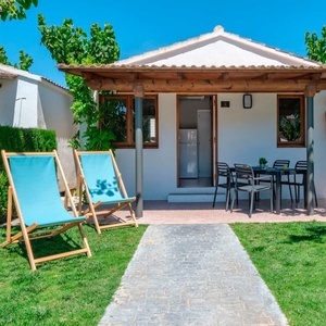 dos tumbonas azules están frente a una pequeña casa blanca