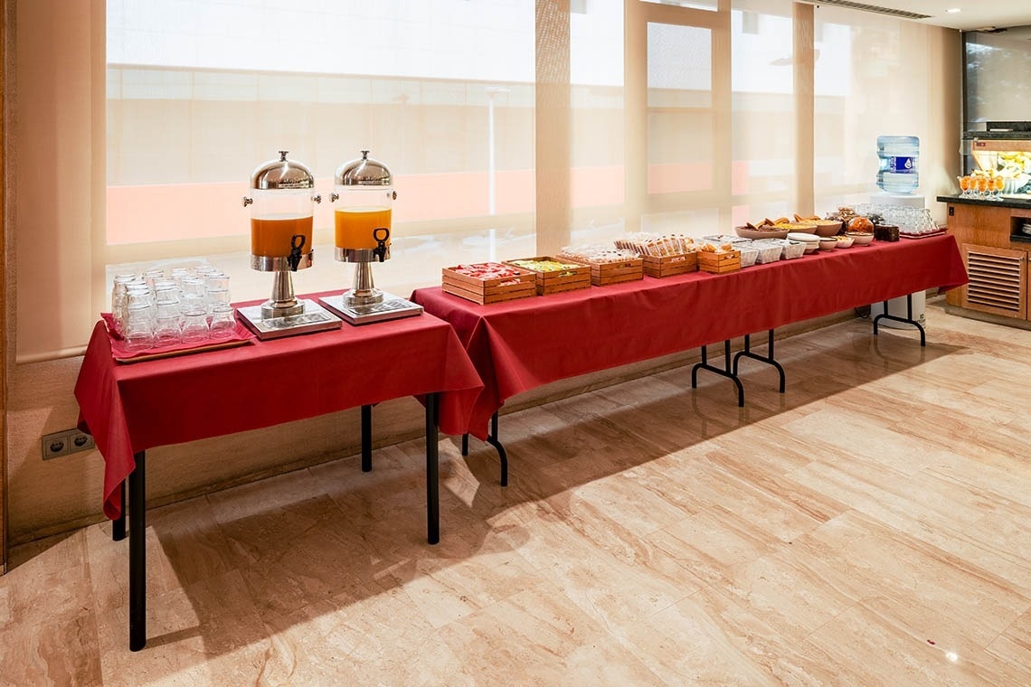 a long buffet table with a red table cloth