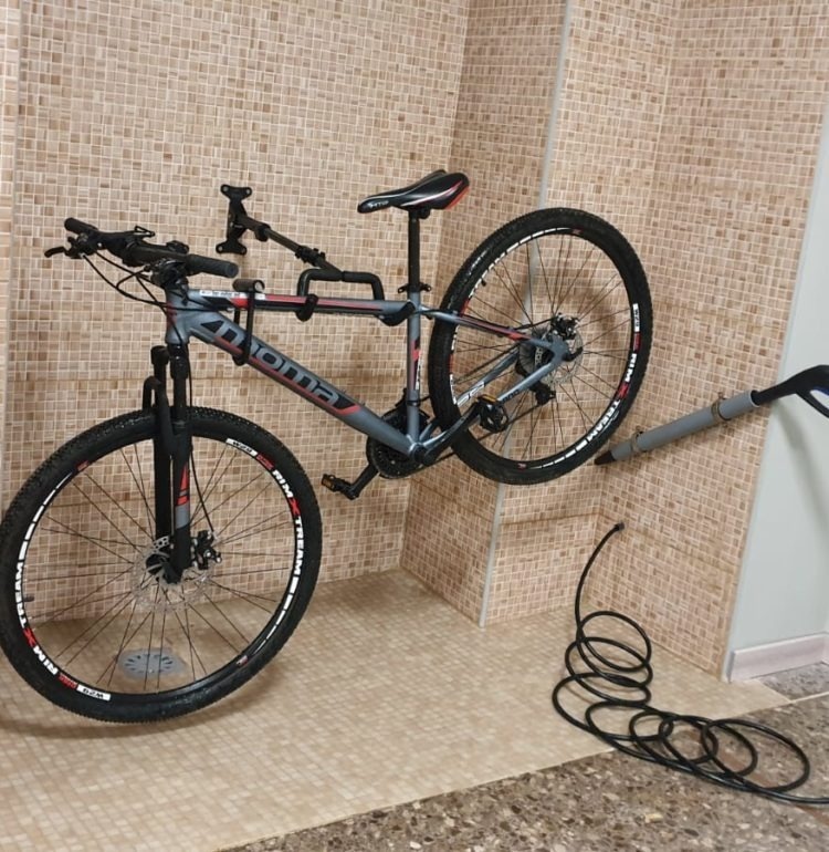 una bicicleta montada en una pared junto a una manguera