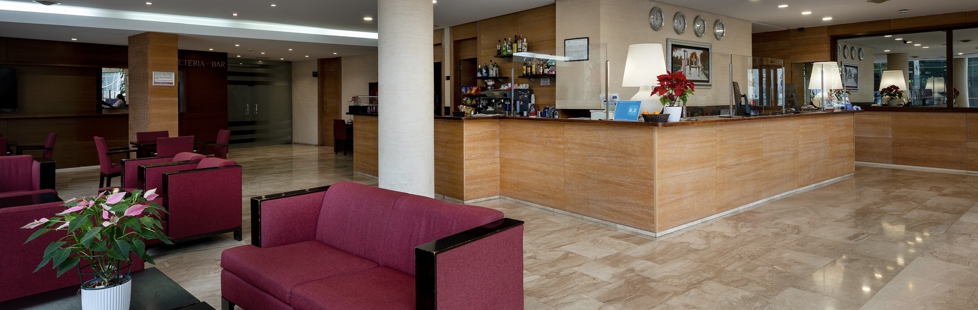 a hotel lobby with red chairs and a counter