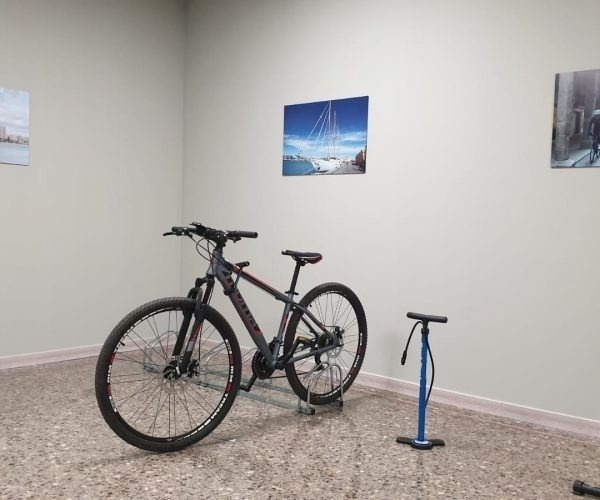 una bicicleta está estacionada en una habitación junto a una bomba de aire