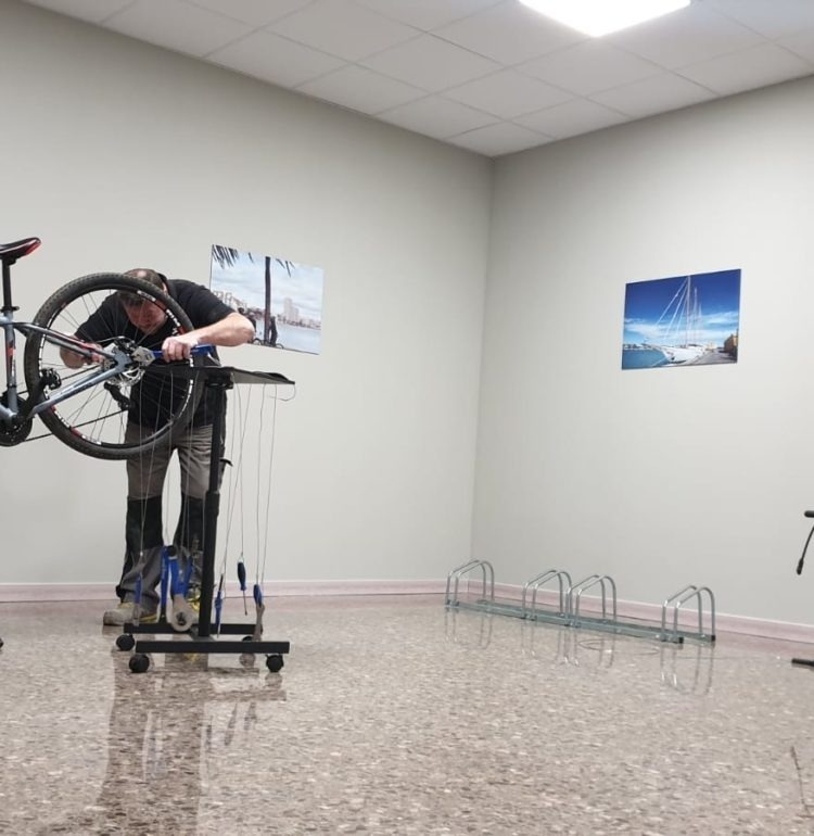 un hombre está reparando una bicicleta en una habitación