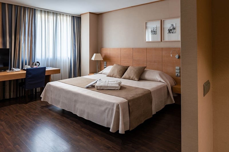 una habitación de hotel con una cama y una mesa de vidrio