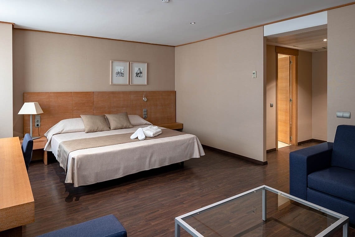 una habitación de hotel con una cama y una mesa de vidrio