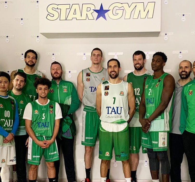 a group of basketball players pose in front of a sign that says star gym