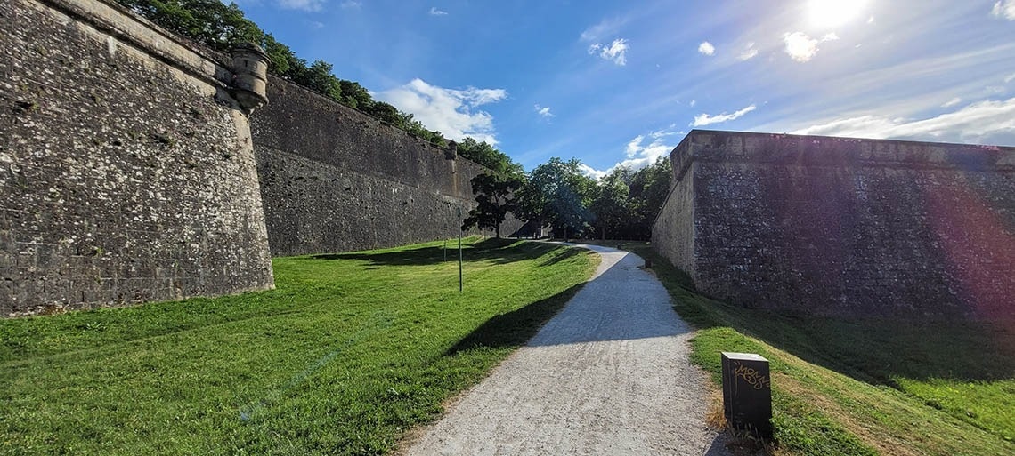 a stone wall with graffiti on the side of it
