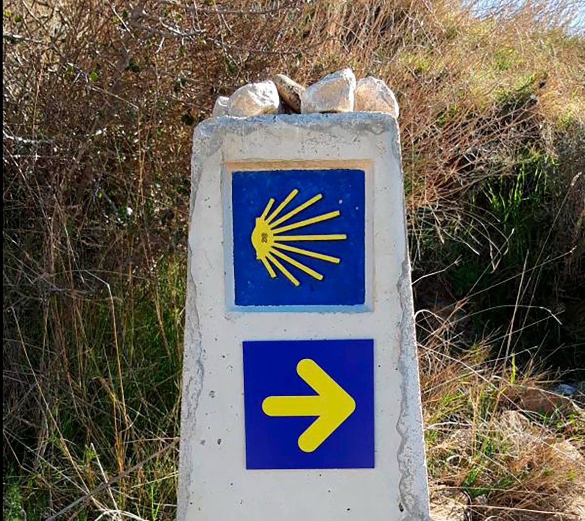 a blue and yellow sign with an arrow pointing to the right