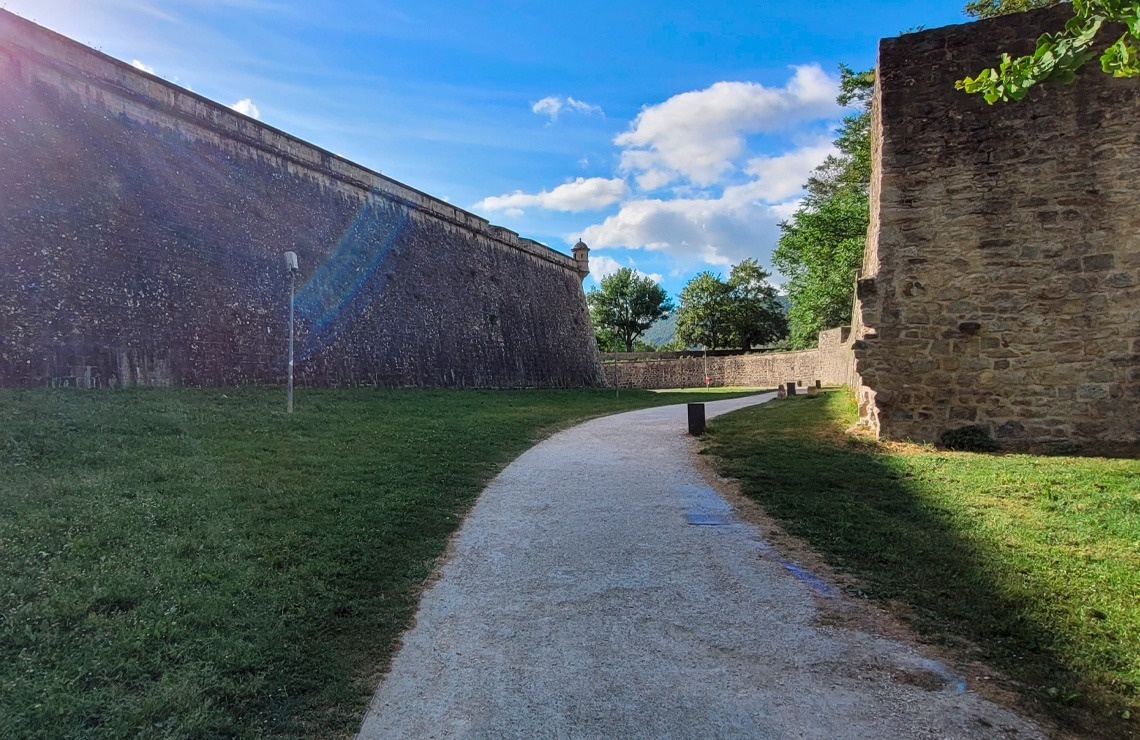 a stone wall along the side of a path