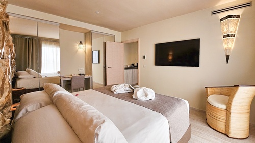 a hotel room with a large flat screen tv on the wall